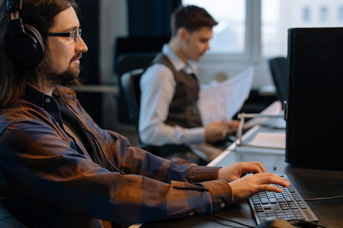 ICT-specialist helpt een medewerker in Lekkerkerk achter de computer